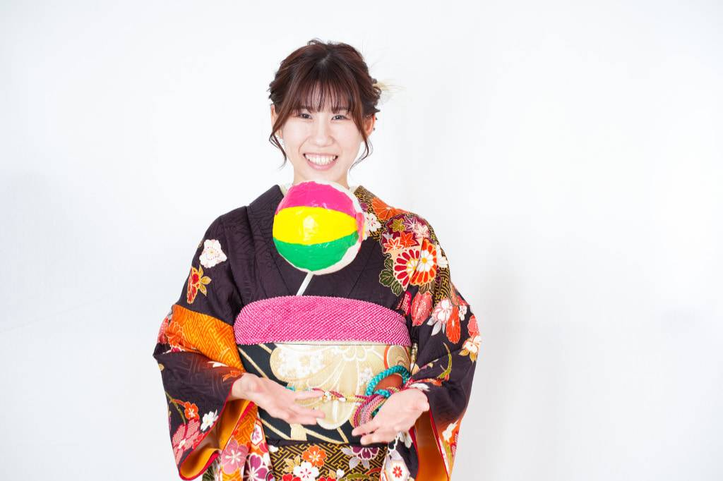 成人式の前撮り写真で紙風船を飛ばす女性