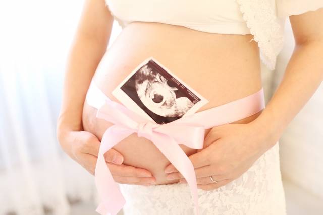 女性がお腹を抱えているマタニティフォト